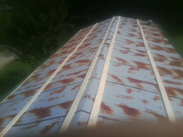 Rusted metal roof panels with new wood purlins before replacement — Storm Damage Roof Repair in Hanscom Afb by Roofing Brothers