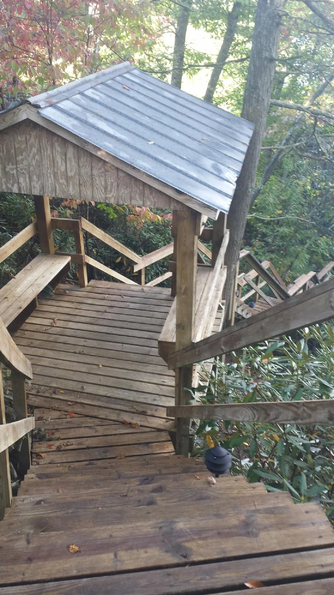Metal roofed shelter over wooden steps on a wooded walkway — Skylight Repair & Installation work by our crew in Hanscom Afb